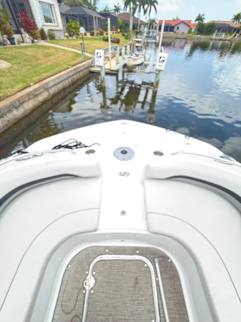 Slide: The Image of The boat is docked in a calm canal with manicured gardens and palm trees in the background. - 15