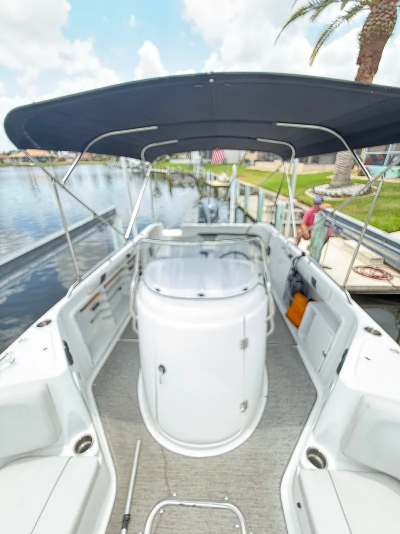 Slide: The Image of The image shows the cockpit of a Hurricane 231 SS boat with a Bimini top. - 16