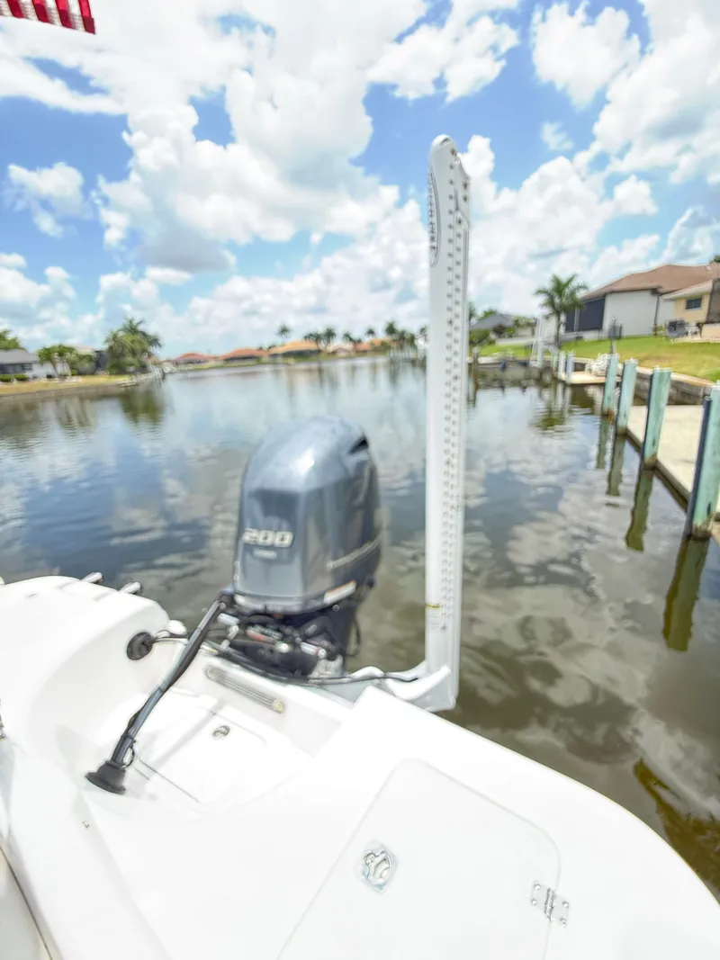 Slide: The Image of A boat with an outboard motor on calm water, surrounded by houses and palm trees. - 24