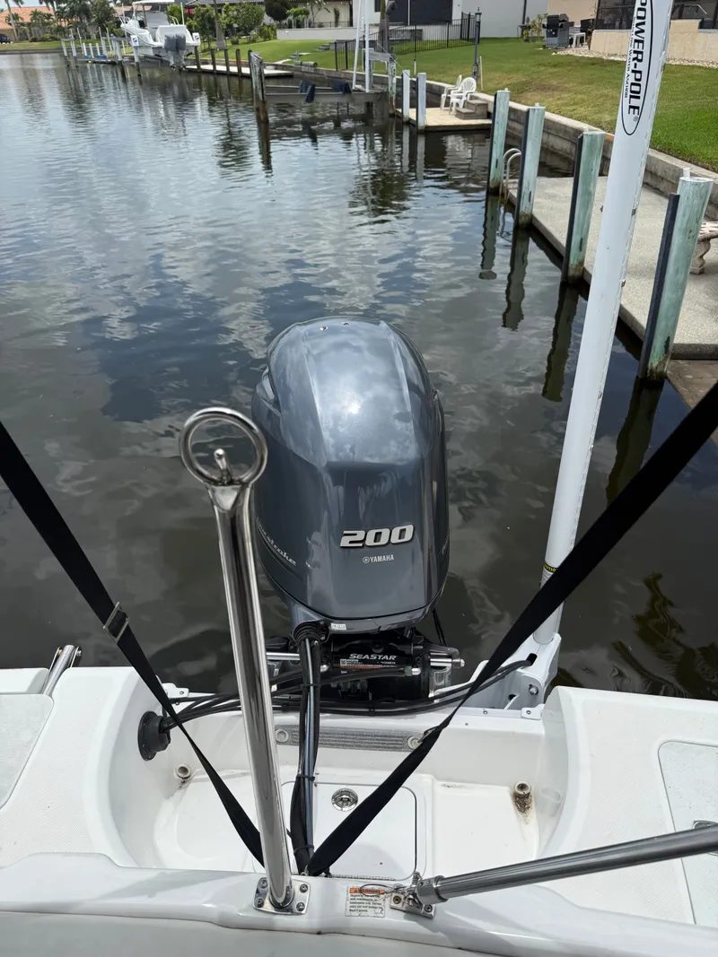Slide: The Image of A Hurricane 231 SS boat with a Yamaha 200 outboard motor, docked in a calm canal. - 26
