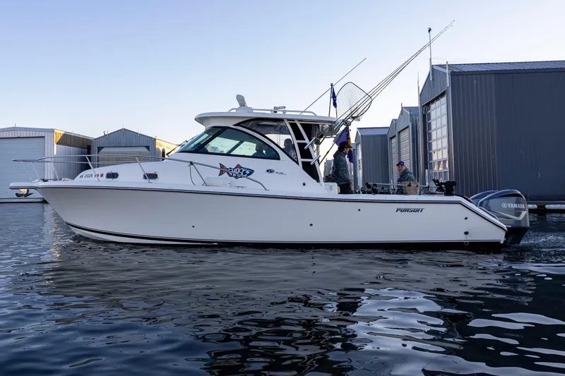 Slide: The Image of 2010 Pursuit OS 345 Offshore boat docked near marina buildings. - 4