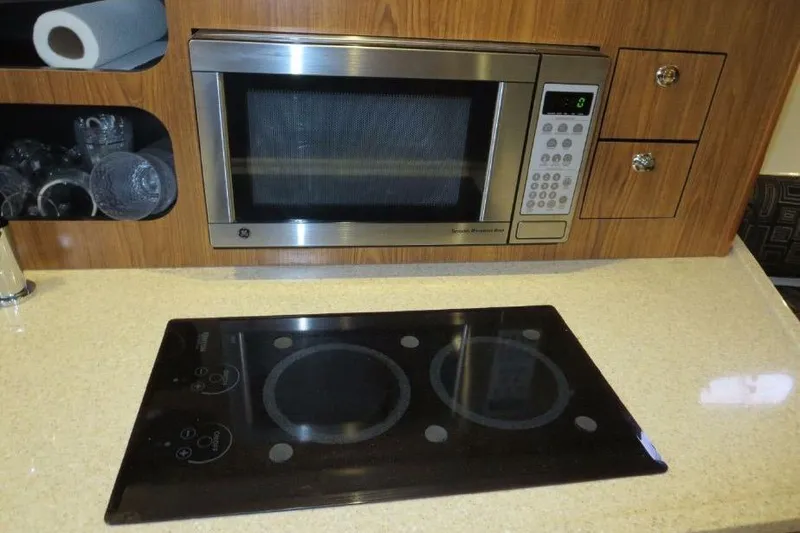 Slide: The Image of Modern kitchen in 2010 Pursuit OS 345 Offshore boat with microwave and stovetop. - 16