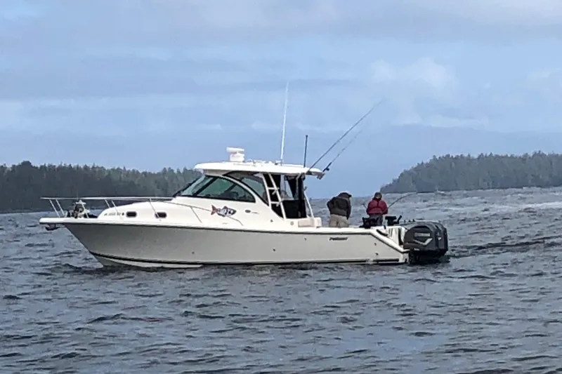 The Image of 2010 Pursuit OS 345 Offshore boat on water, two people fishing, scenic background. - 1
