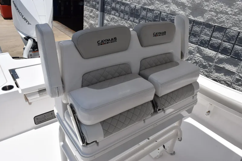Slide: The Image of 2022 Caymas 26 HB boat seating with quilted upholstery and Mercury engine in background. - 10