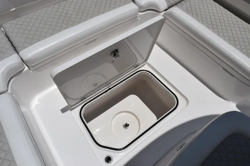 Slide: The Image of 2022 Caymas 26 HB boat with open storage compartment and cushioned seating. - 17