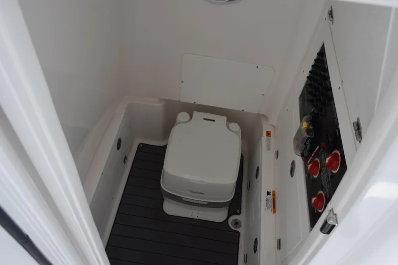 Slide: The Image of 2022 Caymas 26 HB boat interior with portable toilet and control panel. - 20