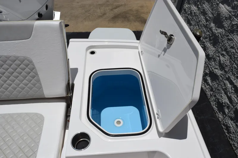Slide: The Image of 2022 Caymas 26 HB boat with open storage compartment and cushioned seating. - 24