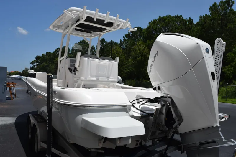 Slide: The Image of 2022 Caymas 26 HB boat with Mercury engine, parked outdoors on a sunny day. - 6