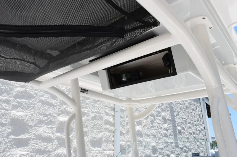 Slide: The Image of 2022 Caymas 26 HB boat T-top with storage compartment and mesh netting. - 9