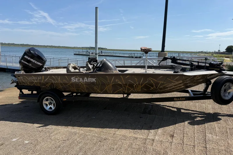 Slide: The Image of 2010 SeaArk Stealth 190 boat with Mercury outboard motor on trailer by a lake. - 14
