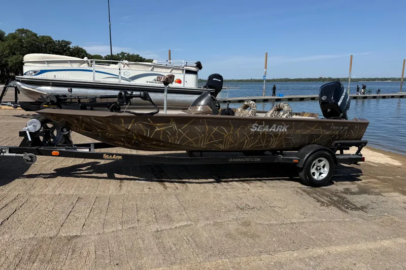 Slide: The Image of 2010 SeaArk Stealth 190 boat on trailer by a lakeside dock. - 3