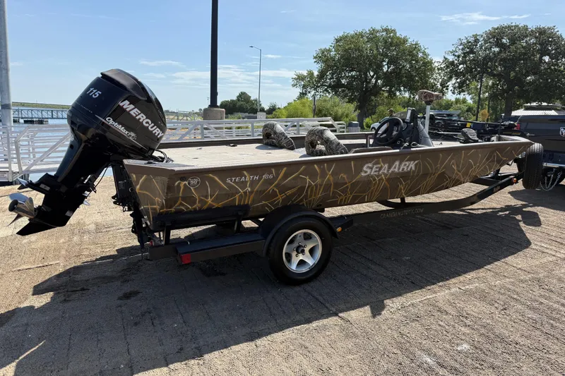 Slide: The Image of 2010 SeaArk Stealth 190 boat with Mercury engine on trailer, parked near a dock. - 13