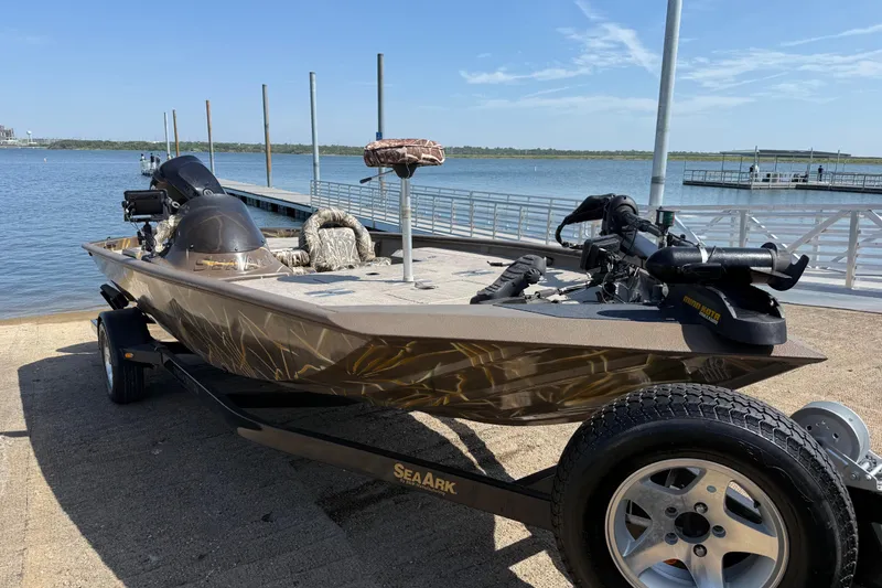 Slide: The Image of 2010 SeaArk Stealth 190 boat on trailer by a lakeside dock. - 16