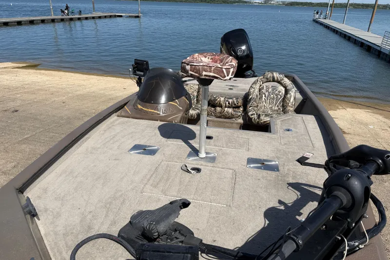 Slide: The Image of 2010 SeaArk Stealth 190 boat at a lakeside dock with camo seats. - 19