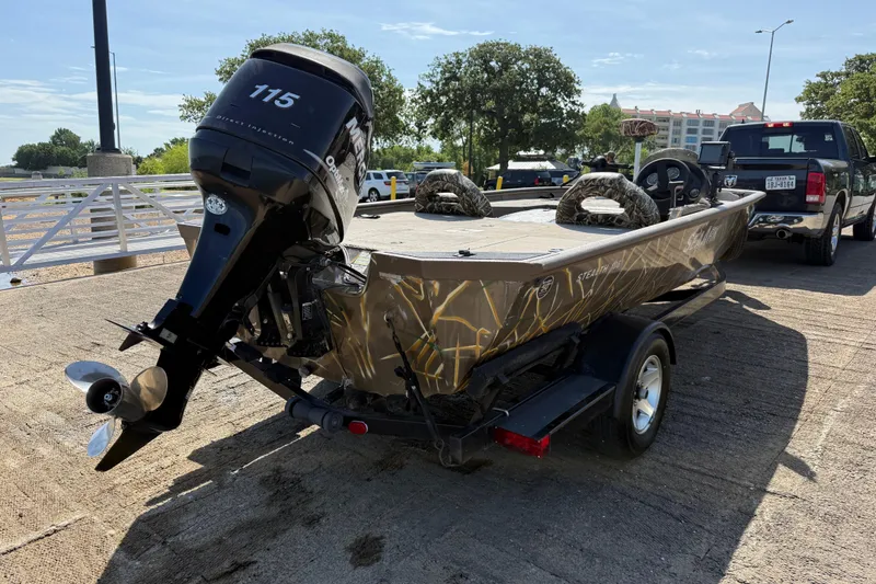 Slide: The Image of 2010 SeaArk Stealth 190 boat with 115 HP motor on trailer, parked outdoors. - 12