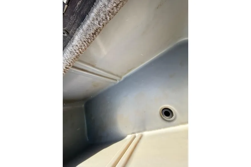 Slide: The Image of Interior view of a 2010 SeaArk Stealth 190 boat compartment with drain hole. - 27
