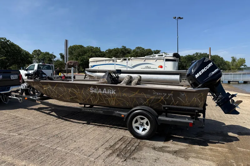 Slide: The Image of 2010 SeaArk Stealth 190 boat on trailer with Mercury outboard motor at a boat ramp. - 6