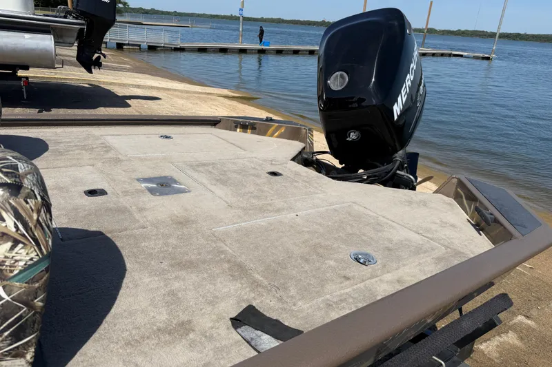 Slide: The Image of 2010 SeaArk Stealth 190 boat with Mercury engine at a lakeside dock. - 25
