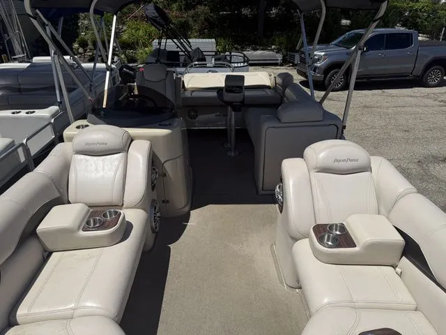 Slide: The Image of Interior of a Godfrey AP 240 pontoon boat with beige seating and cup holders. - 4