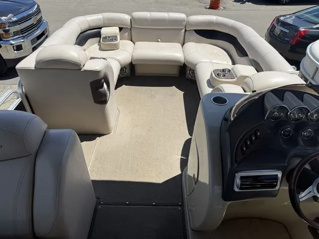 Slide: The Image of Interior of a Godfrey AP 240 pontoon boat with beige seating and dashboard. - 6