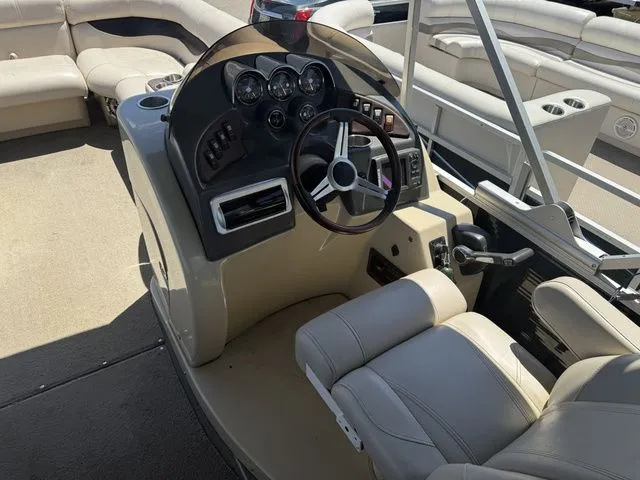 Slide: The Image of The image shows the helm of a 2014 Godfrey AP 240 pontoon boat with beige seating. - 7
