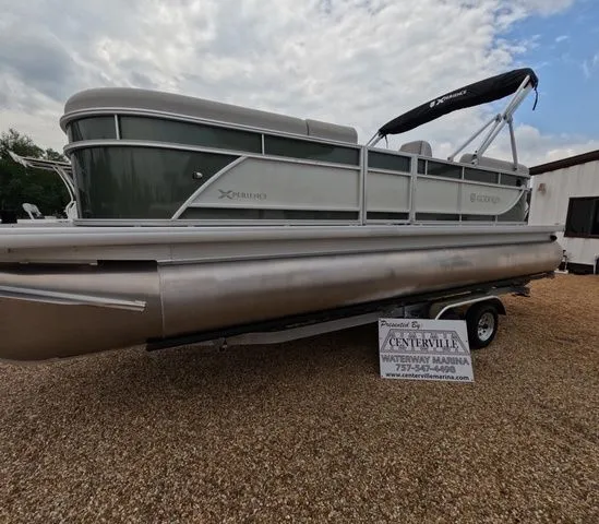 The Image of Godfrey Xperience Lounge 2286 SBX pontoon boat on a trailer, ready for adventure. - 1