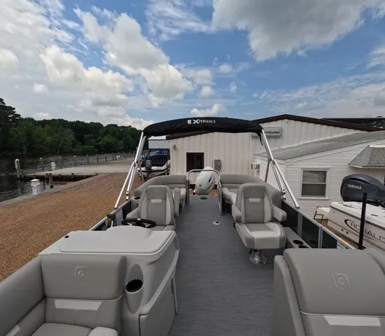 Slide: The Image of The image shows a modern pontoon boat with gray seating and a black sunshade, docked at a pier. - 25