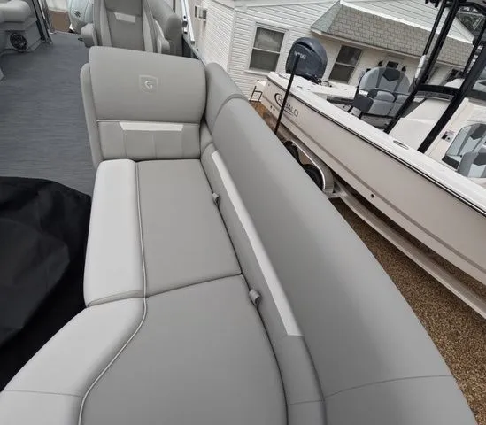 Slide: The Image of Gray upholstered bench on a boat, with another boat in the background. - 26