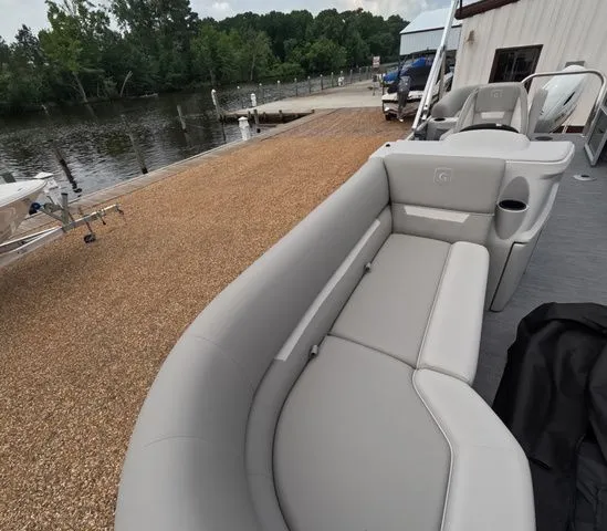 Slide: The Image of The image shows the gray seating of a Godfrey Xperience Lounge 2286 SBX at a dock. - 27