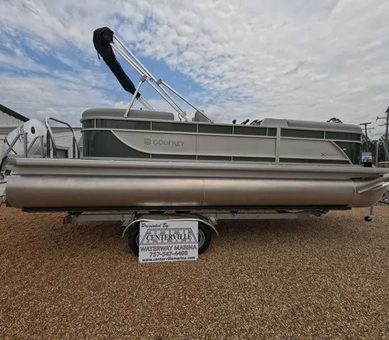 Slide: The Image of A 2027 Godfrey Xperience Lounge 2286 SBX pontoon boat on a trailer in a gravel lot. - 5