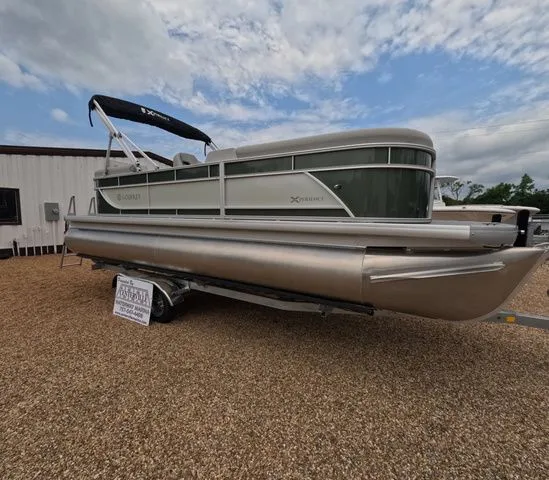 Slide: The Image of A 2027 Godfrey Xperience Lounge 2286 SBX pontoon boat on a trailer in a gravel lot. - 6