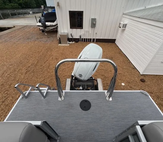 Slide: The Image of Rear view of a boat with motor and ladder, on a gravel lot next to a building. - 7