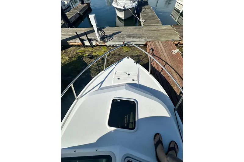 Slide: The Image of 2022 Parker 2120 Sport Cabin boat docked at marina, viewed from bow. - 10