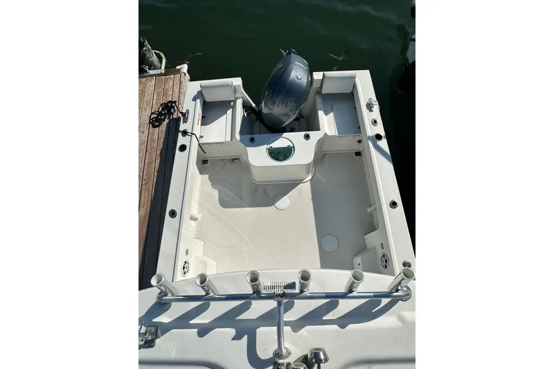 Slide: The Image of 2022 Parker 2120 Sport Cabin boat with outboard motor, docked on calm water. - 11