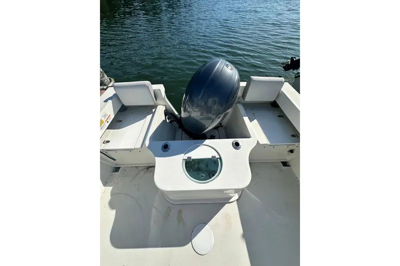 Slide: The Image of 2022 Parker 2120 Sport Cabin boat with outboard motor on calm water. - 12