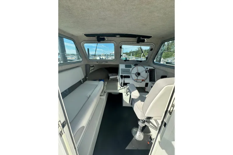 Slide: The Image of Interior of 2022 Parker 2120 Sport Cabin boat, featuring helm and seating area. - 14