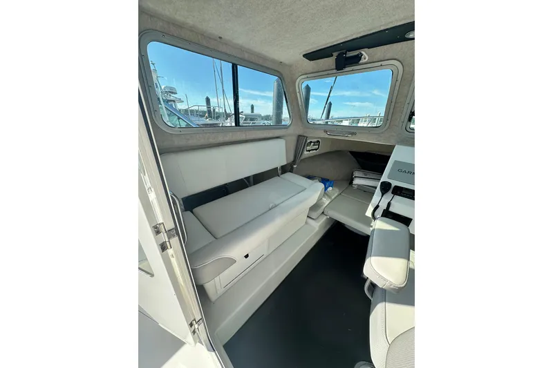 Slide: The Image of Interior of 2022 Parker 2120 Sport Cabin boat, featuring seating and windows. - 15