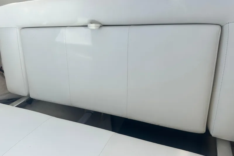 Slide: The Image of White cushioned seating in a 2022 Parker 2120 Sport Cabin boat interior. - 17