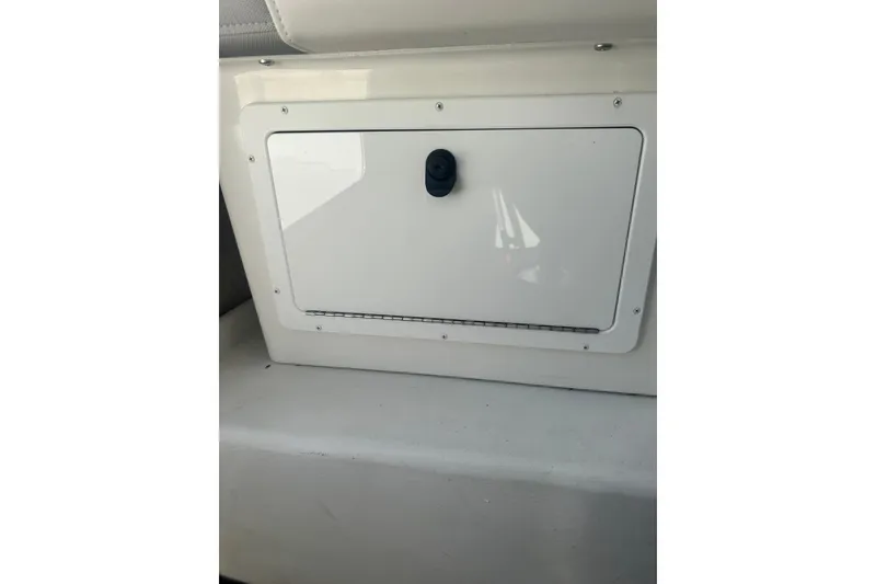 Slide: The Image of Storage compartment on a 2022 Parker 2120 Sport Cabin boat interior. - 18