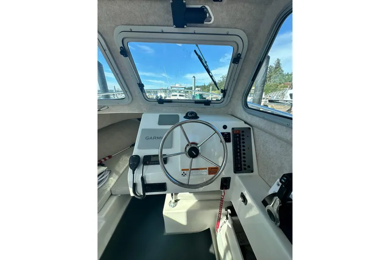 Slide: The Image of Interior view of 2022 Parker 2120 Sport Cabin boat with steering wheel and controls. - 21