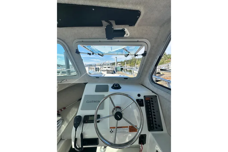 Slide: The Image of Interior view of 2022 Parker 2120 Sport Cabin boat with steering wheel and Garmin equipment. - 24