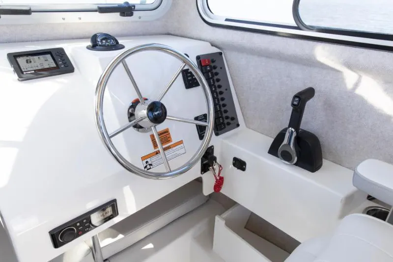 Slide: The Image of Manufacturer Provided Image: Interior helm of 2022 Parker 2120 Sport Cabin boat with steering wheel and control panel. - 39