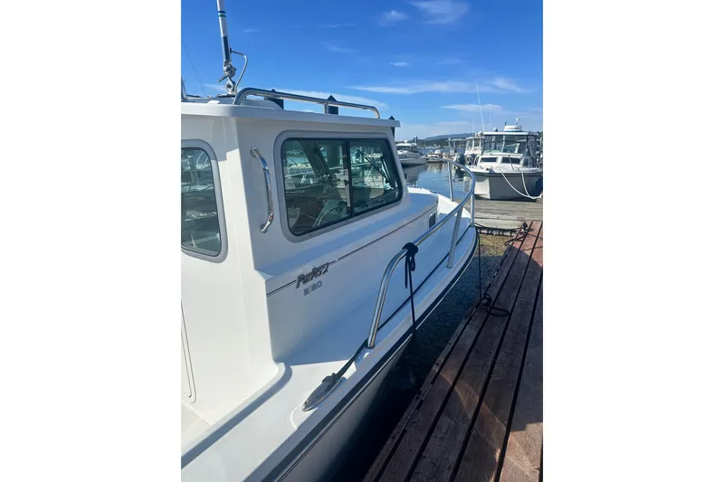 Slide: The Image of 2022 Parker 2120 Sport Cabin boat docked at marina under clear blue sky. - 4