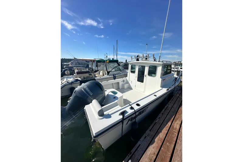 Slide: The Image of 2022 Parker 2120 Sport Cabin boat docked with Yamaha outboard motor. - 6