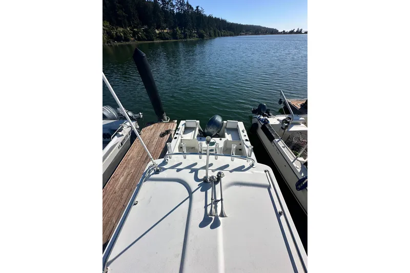 Slide: The Image of 2022 Parker 2120 Sport Cabin docked by a serene lake with lush forest backdrop. - 9