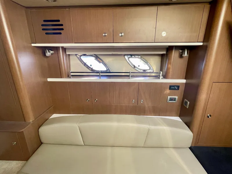 Slide: The Image of Interior of 2014 Sea Ray 330 Sundancer with wooden cabinets and beige seating. - 15