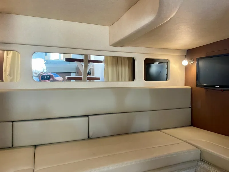 Slide: The Image of Interior of 2014 Sea Ray 330 Sundancer yacht with beige seating and wall-mounted TV. - 17