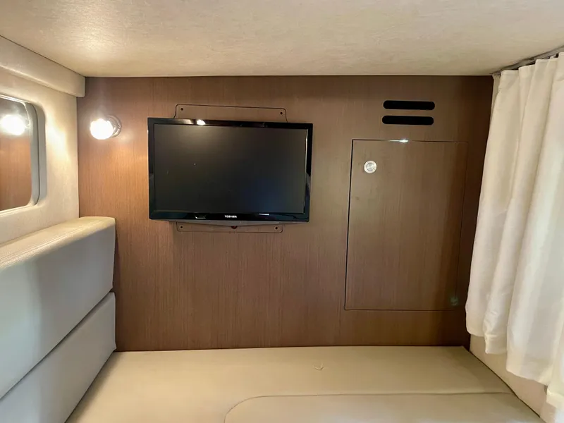 Slide: The Image of Interior of 2014 Sea Ray 330 Sundancer with mounted TV and cozy seating area. - 18