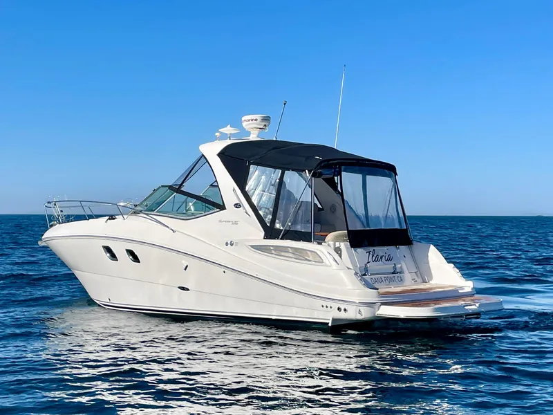 Slide: The Image of 2014 Sea Ray 330 Sundancer cruising on open water under clear blue sky. - 2