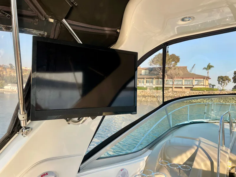 Slide: The Image of 2014 Sea Ray 330 Sundancer interior with mounted TV and scenic water view. - 40